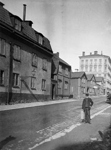 En pojke står på Timmermansgatan norrut från Fatbursgatan. T.v. Timmermansgatan 48-42. Mellan Timmermansgatan 46 och 44 går Bengt Ekehjelmsgatan. Flerbostadshuset ligger vid Högbergsgatan 70