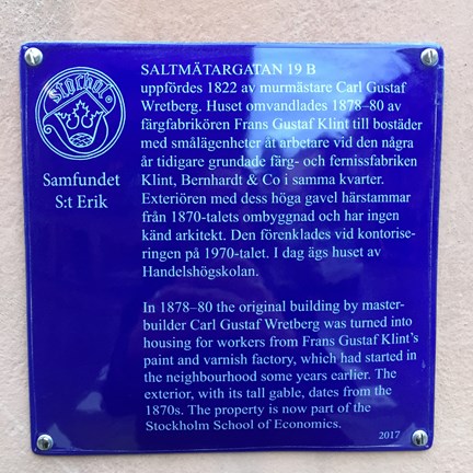 Blå emaljskylt med vit text om ett hus på Saltmätargatan.