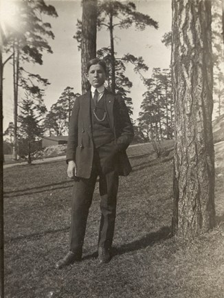 Foto på Mulle Österkvist i kostym stående i en tallbacke.