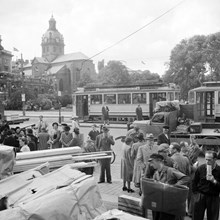 Folksamling på Strömgatan vid Karl XII:s Torg. Jakobs kyrka i fonden