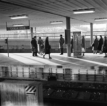 Väntande resenärer vid Gamla Stans tunnelbanestation. På perrongen en choklad -, frukt - och tobaksautomat