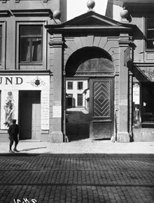 En pojke passerar vid Götgatan 28. Portal och port mot gården där Freys express har en filial. Nuvarande Götgatan 32