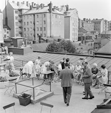 Sommarklädda människor samlade på takterrass på Bonnierhuset, Sveavägen 56