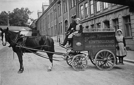 Hästdragen mjölkvagn vid Fleminggatan med kusk och två kvinnliga biträden.