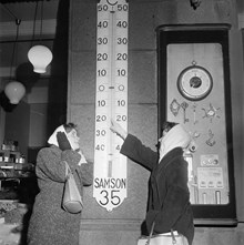En kylig februaridag i Stockholm. Två ungdomar pekar på en termometer som visar 22 minusgrader, den kallaste februaritemperaturen i Stockholm sedan 1940
