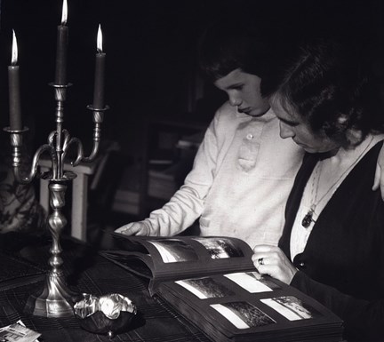 Reklambild (stämningsbild) med stearinljus och fotoalbum. Fotograf: C.G. j:r Rosenberg, period 1930-1939
