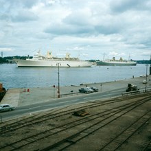 Passagerarfartygen Kungsholm och Nieuw Amsterdam (Holland) för ankar på Strömmen. Vy från Östra Slussgatan över Stadsgårdsleden