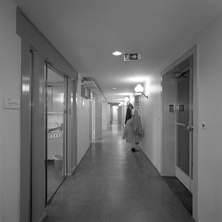 Korridor. Ett pentry skymtar till vänster. På höger sida står en klädhängare.