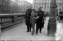 Två poliser på Norrbro håller den ryske medborgaren Josef Skoutelsky mellan sig i ett fast grepp.