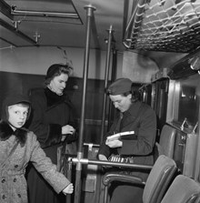 Interiör från en buss med passagerare och en konduktör