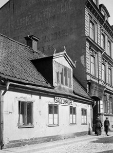 Luntmakargatan 32-34. På första skylten fr. v. står det: Sadelmakare, på den andra: Stockholms Hofslageri aktiebolags vagnfabrik