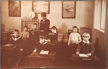 Svartvitt fotografi på barn i sina skolbänkar på Beskowska skolan