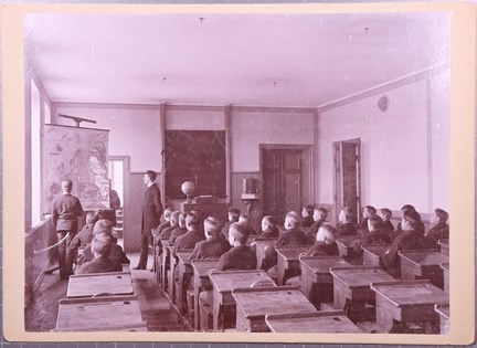 Svartvitt fotografi på pojkar i lektionssal på uppfostringsanstalten Åkerbrukskolonin Hall
