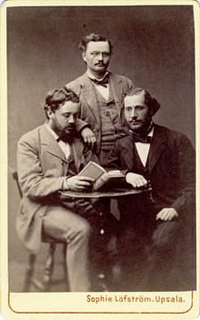 Visitkort med porträttbild av Knut Wicksell tillsammans med Hjalmar Öhrvall till vänster och Theodor Frölander till höger.