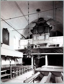 Interiör av Finska kyrkan från altaret mot bänkraderna och orgelläktaren