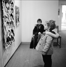 Liten pojke betraktar textilt verk på utställning i Moderna museet