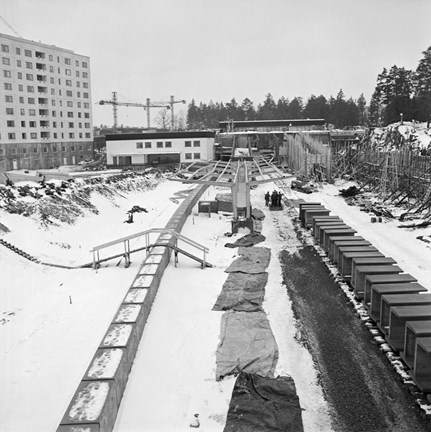 Det byggs för fullt trots januarikylan. Sätra är en förort i sydvästra Stockholm som bebyggdes under 60-talet. Stockholm stad köpte upp marken i området 1961 och 1964 började man bygga och fyra år senare var Sätra i det närmaste färdigställd. Tunnelbanestationen invigdes 16 maj 1965 och stationen fungerade som slutstation för linje 13 till 1 mars 1967. Centrumet består av ett överbyggt torg och var Stockholms första inomhuscentrum. 