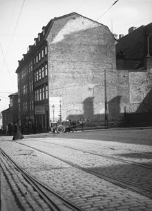 Hornsgatan 3 och 1 österut. En skylt med texten ""Skodon billigt"" syns på fasaden. En häst med kärra passerar rivna Hornsgatan 5. Vy österut från Repslagargatan