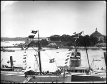 Flaggspel på båtar vid Skeppsbrokajen med anledning av Kejsar Vilhelm II:s besök. I bakgrunden Skeppsholmen