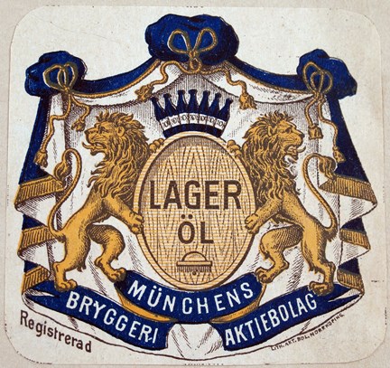 Öletikett tryckt i gult, brunt och blått. Bild vapen med lejon och krona samt text.