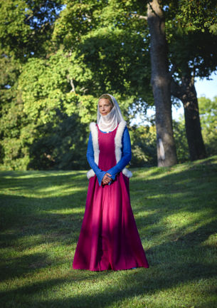 Kvinna klädd i en återskapad 1300-tals klänning.
