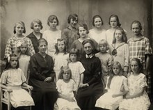 Gruppbild med halvstora flickor och personal. Kungsholms barnhem 1920.