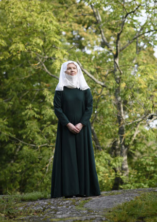 Kvinna klädd i 1300-talsdräkt.