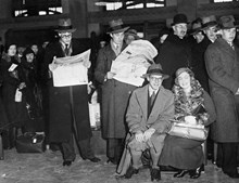 Köande och tidningsläsande personer på Centralstationen. På väskan sitter Sven Sköldberg och Gerd Friman som är på väg till Gent i Belgien.