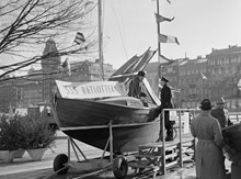 Nybroplan. Stockholms Segelsällskap, SSS, säljer lotter från en segelbåt