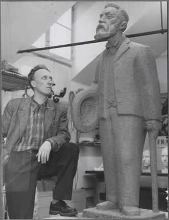 Fotografi av Ture Edvard Johansson i sin ateljé. Med statyn Mäster Palm. 