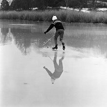 Pojke spelar bandy på blankfrusen sjö