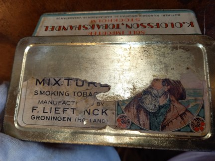 Burklock. Bild av sjöman, bortnött.  Text på locket: ”Mixture smoking tobacco. Manufactured by F. Lieft nck Groningen (Holland)” 