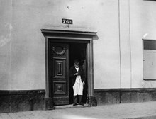 En man står i porten till Götgatan 76 A. Nuvarande Götgatan 138. I kvarteret ligger nu Åhléns varuhus på Södermalm