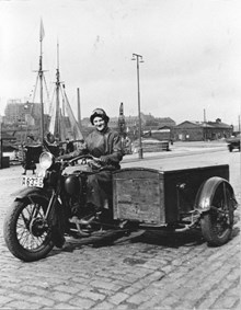 Kvinna på motorcykel med vagn vid Klara Strand