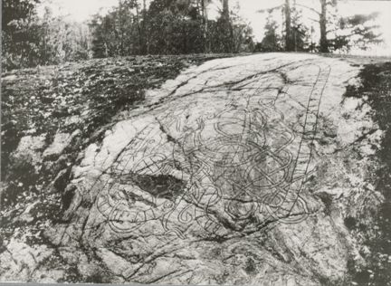 Svartvitt foto på runor i berghäll. 