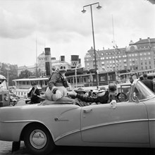 Nybrokajen. Kalle Anka och Långben i en öppen bil genom Stockholm