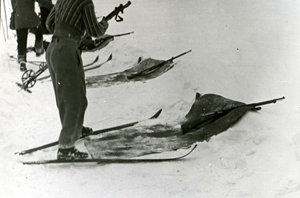 Personer med skidor och gevär.