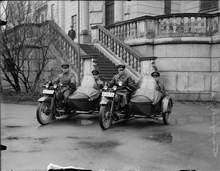 Motorcykelpatrull med trafikpoliser framför polishuset