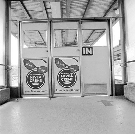 Reklam för Nivea creme på dörrar ut till perrongen vid Åkeshovs tunnelbanestation