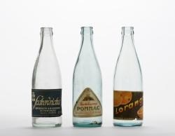 Tre läskedrycksflaskor i Stadsmuseets samling. Foto: Fredrik Sweger, Stockholms stadsmuseum.