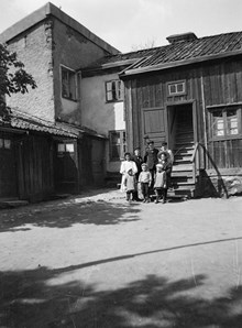 En grupp barn står på gårdssidan av Tavastgatan 55 mot norr. Husen t.v. ligger mot Stora Hargränd. Dåvarande kv. Haren Större. Nu kv. Haren söder om Gamla Lundagatan