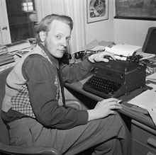Författaren Per Anders Fogelström vid sitt skrivbord på Folket i Bilds kontor på Klara Västra Kyrkogata 5. Utsikt mot Klara Västra Kyrkogata 10.