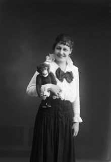Porträttbild av kvinna med leksaksapa i famnen