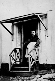 Fru Anna Maria Yhl, född Borgsten på trappan till sin lägenhet i huset Riddargatan 32