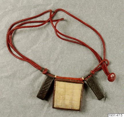 Halsband med amulett av rött läder, ben och metall.