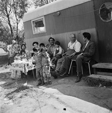 Romsk familj framför sin husvagn.