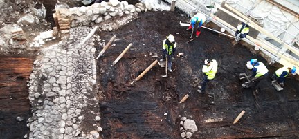 På bilden syns den stenlagda gränden som löpte ner mot Saltsjön. I mitten av gränden fanns en ränna som ledde bort regnvatten. På ömse sidor om gränden fanns en tät bebyggelse som rivits och bränts. I bakgrunden syns grundmuren till en källare som antagligen byggdes 1599. Till vänster i bild ses fem arkeologer arbeta. 