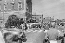 Reportage kring Kungabröllopet den 19 juni 1976. Högvakten marscherar på Skeppsbron vid Slottsbacken. I förgrunden en man med filmkamera