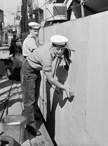 Besättningsmän rengör Brittiska fiskeriinspektionens fartyg H.M.S. Cygnets som ankommit till Stockholm