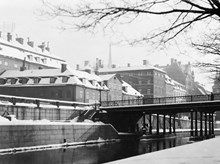 Kv. Atomena och kv. Milon. Vy från Hessensteinska palatset. Den gamla Riddarholmsbron revs 1952 i samband med att tunnelbanan och Centralbron anlades